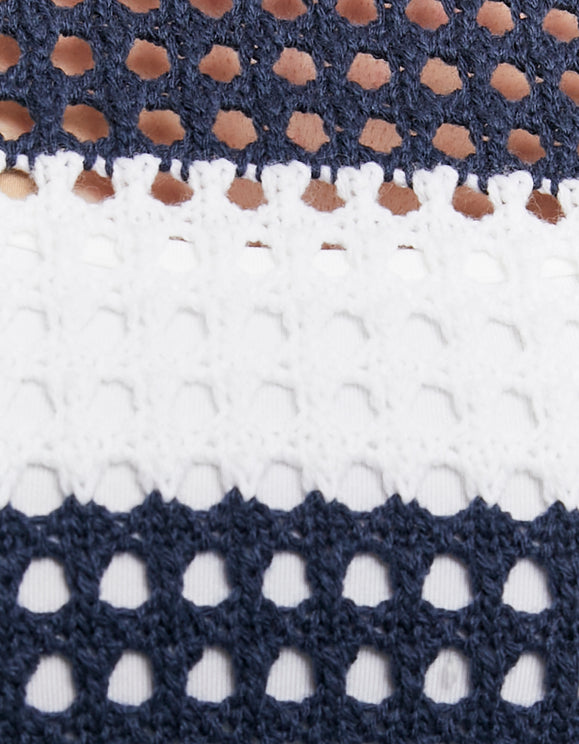 Detail view of the white and navy open-knit striped pullover