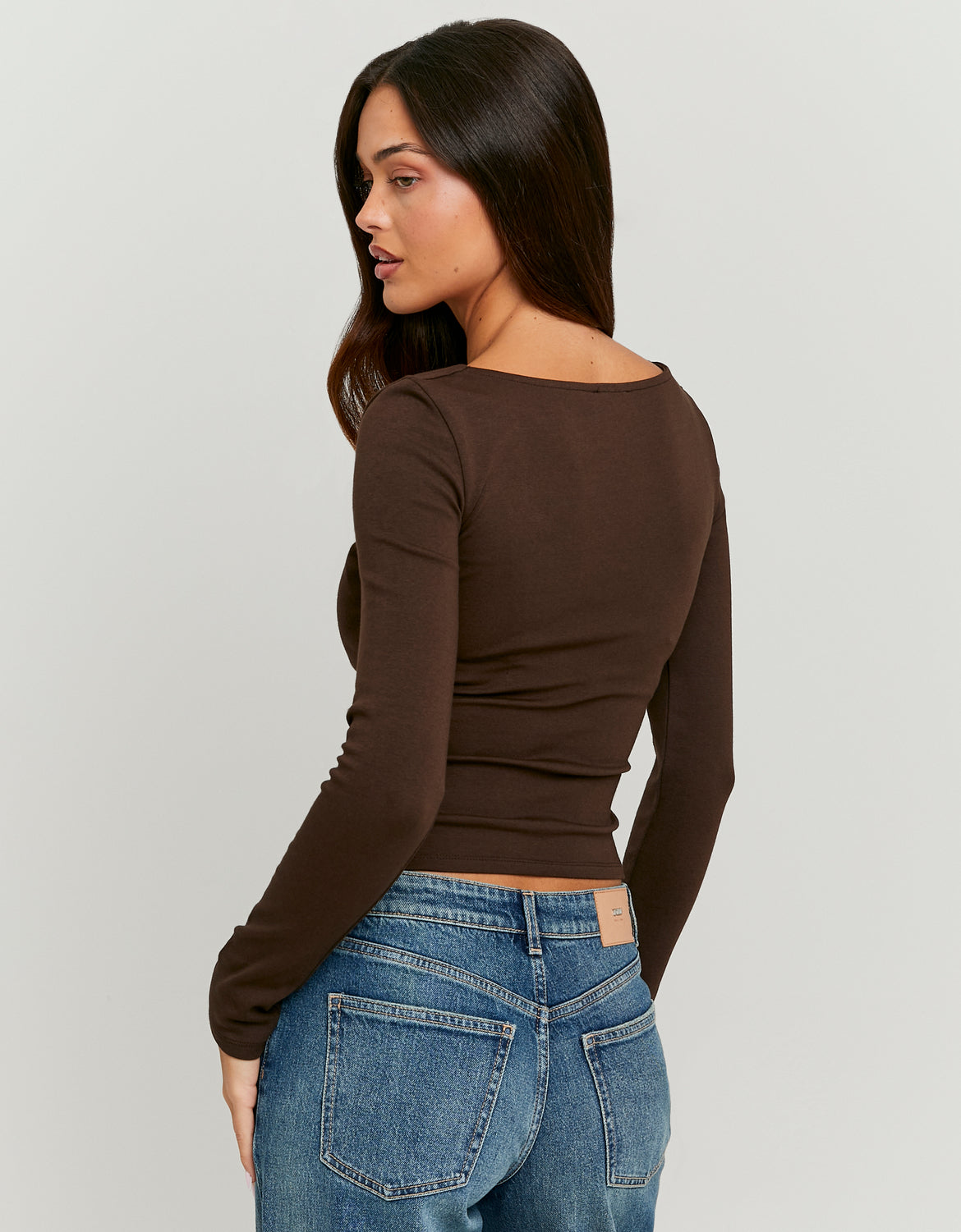 Woman wearing a brown long-sleeve top-Back View
