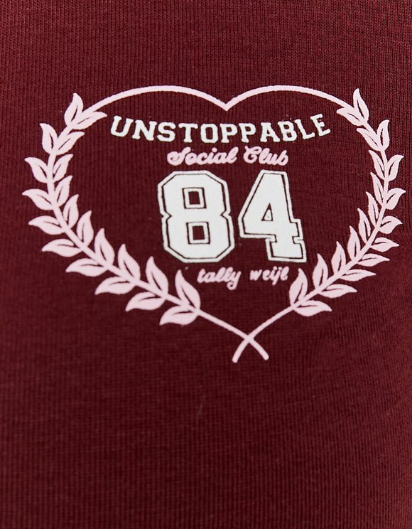 Detail view of the white chest print on the Tally Weijl burgundy polo T-shirt