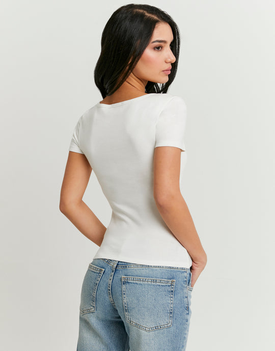 Woman wearing a white t-shirt and blue jeans on a plain background-Back view