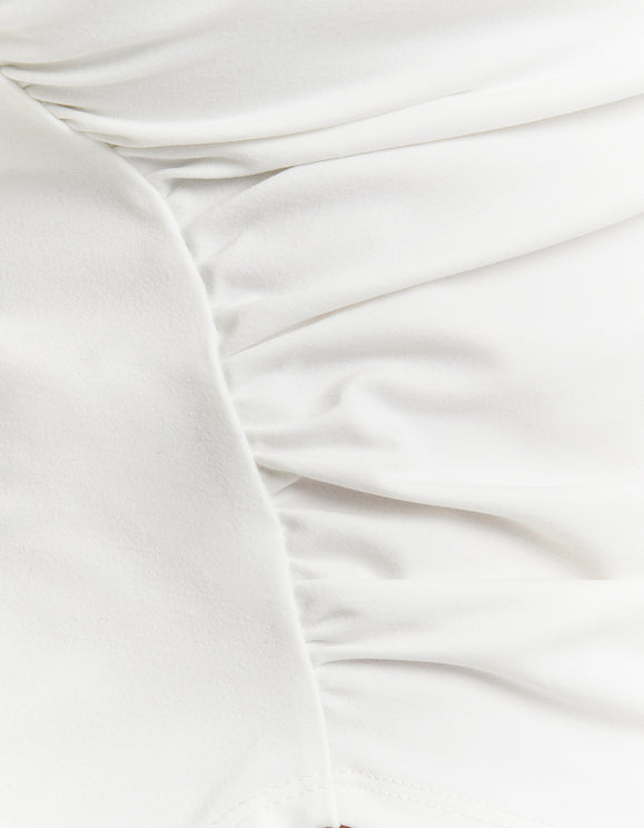 Detail view of pleated side ruching on the Tally Weijl white asymmetric top