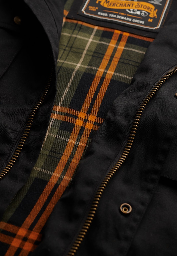 Close-up of a jacket with plaid lining and visible brand label.