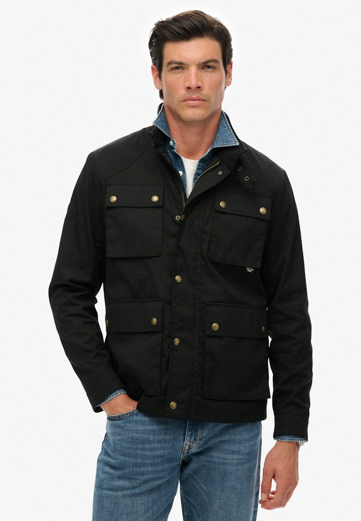 Man wearing a black jacket with gold buttons on a white background