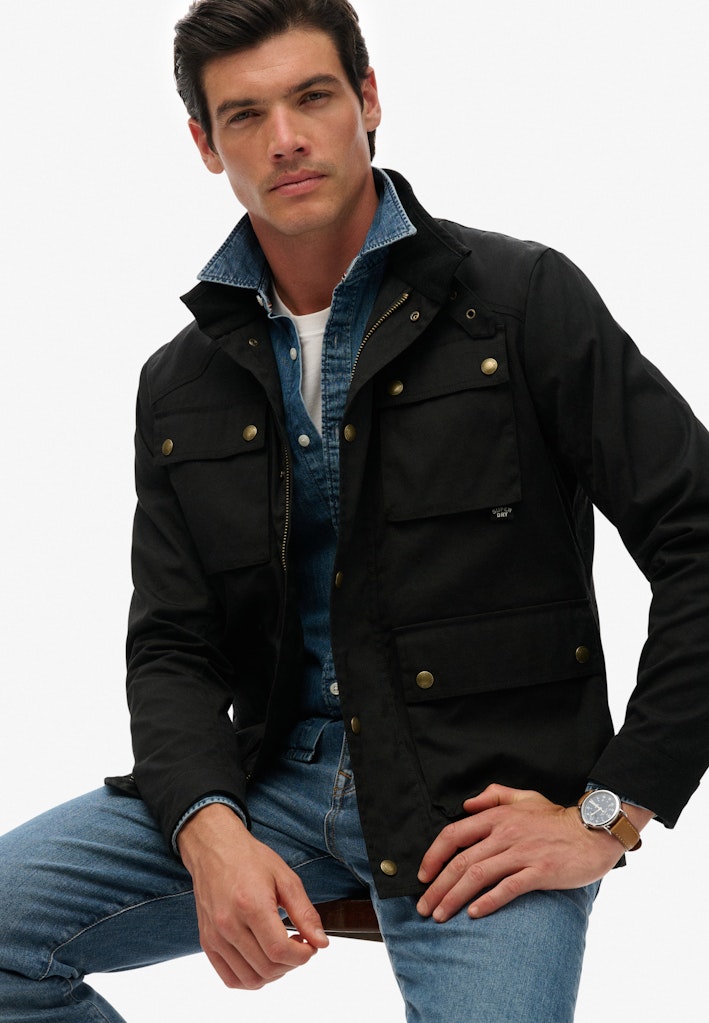 Man wearing a black jacket with gold buttons on a white background
