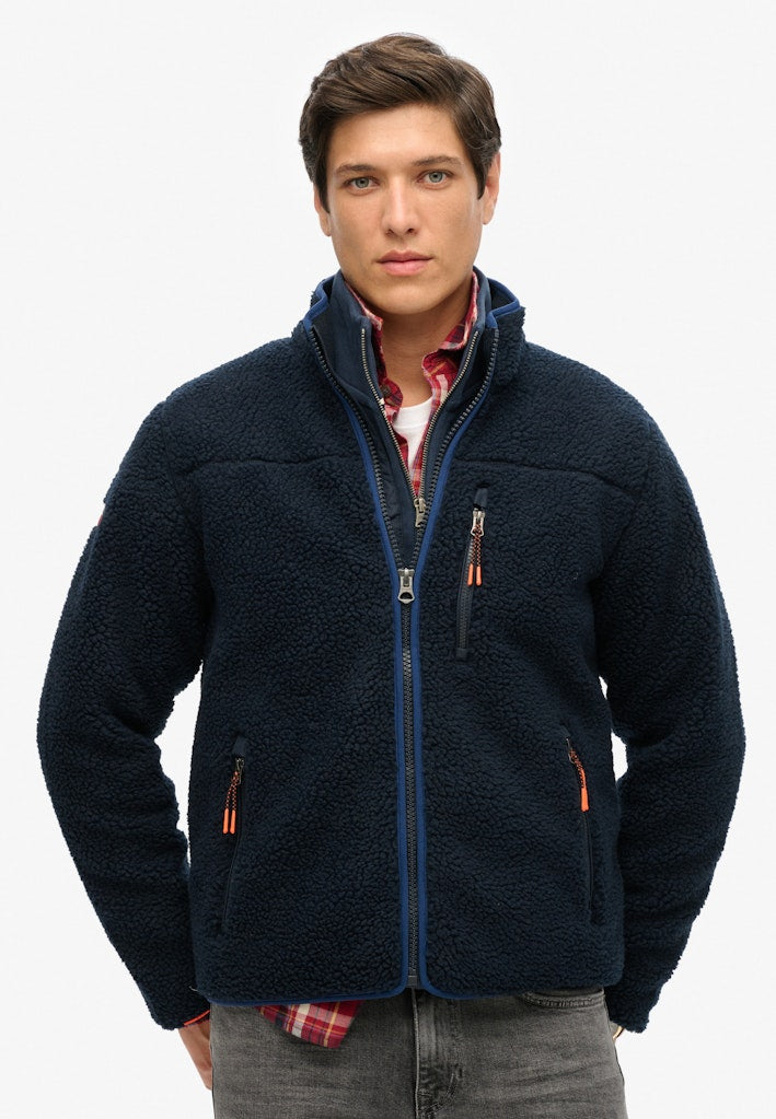 Man wearing a navy blue fleece jacket on a white background