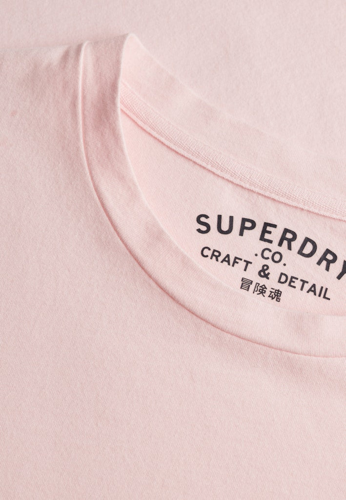 Close-up of a pink Superdry garment with branding details.