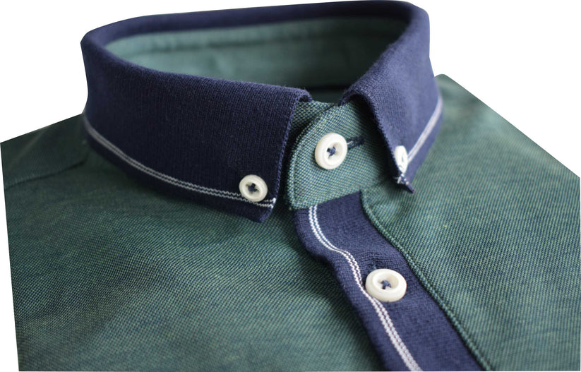 Close-up of a green Tom Penn polo shirt with a navy collar and white buttons on a white background