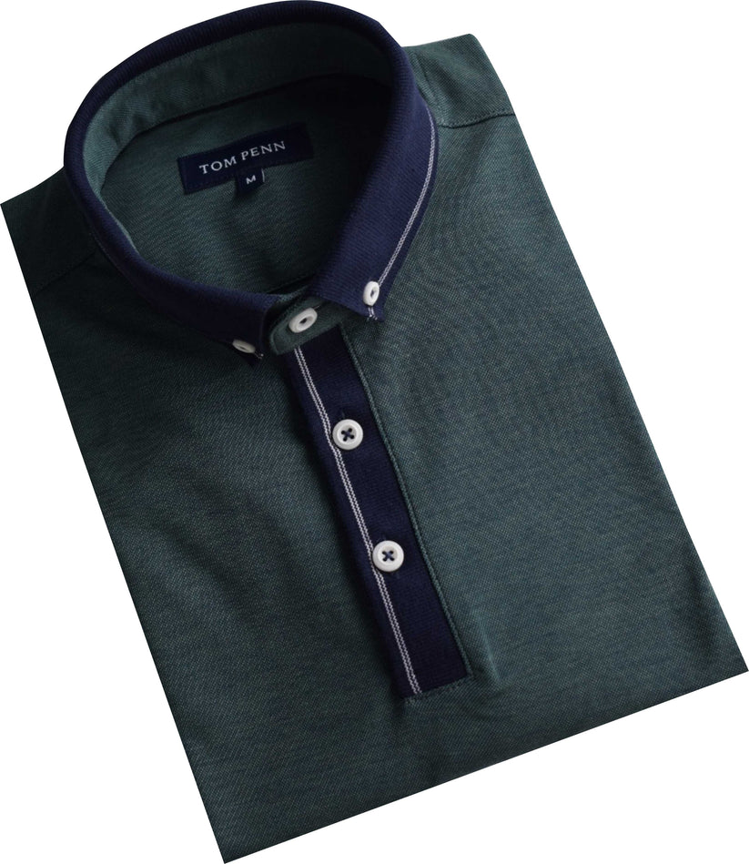 Folded dark greenTom Penn polo shirt with navy collar and buttons on a white background