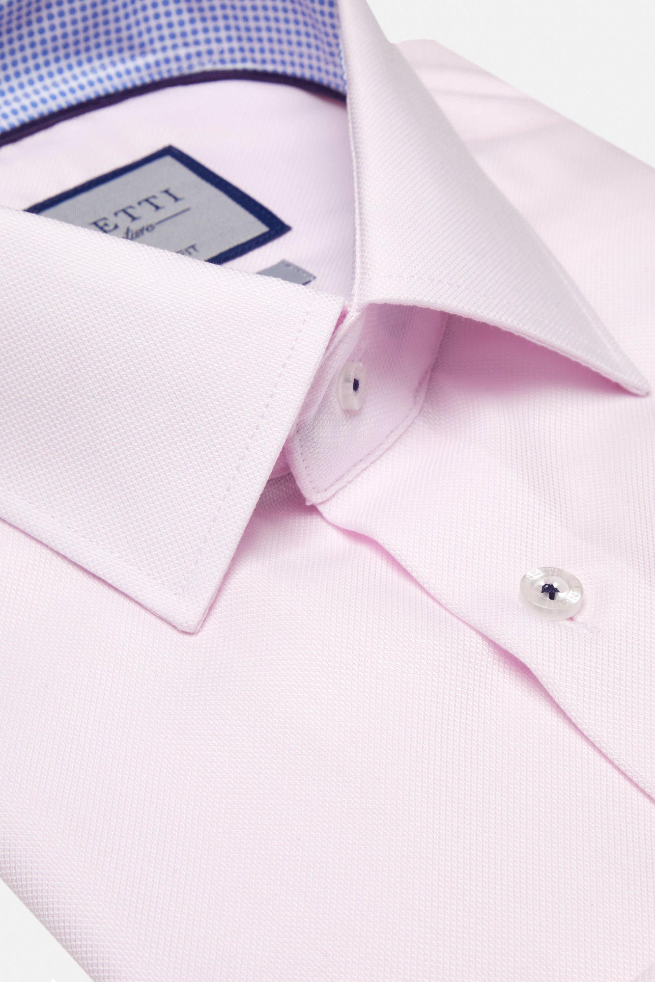 Close-up of a pink dress shirt with cufflinks and a visible brand label.