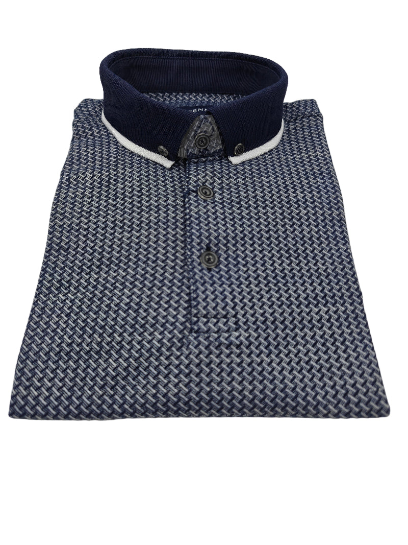 Folded blue patterned shirt with a navy and white collar on a light gray background