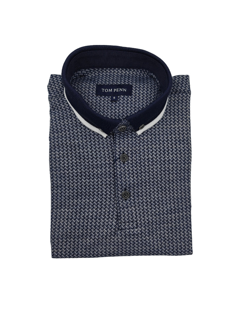Folded navy patterned polo shirt with navy and white collar on a light gray background