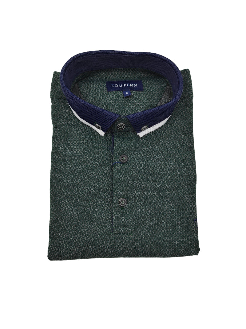 Folded green polo shirt with navy collar on a light gray background