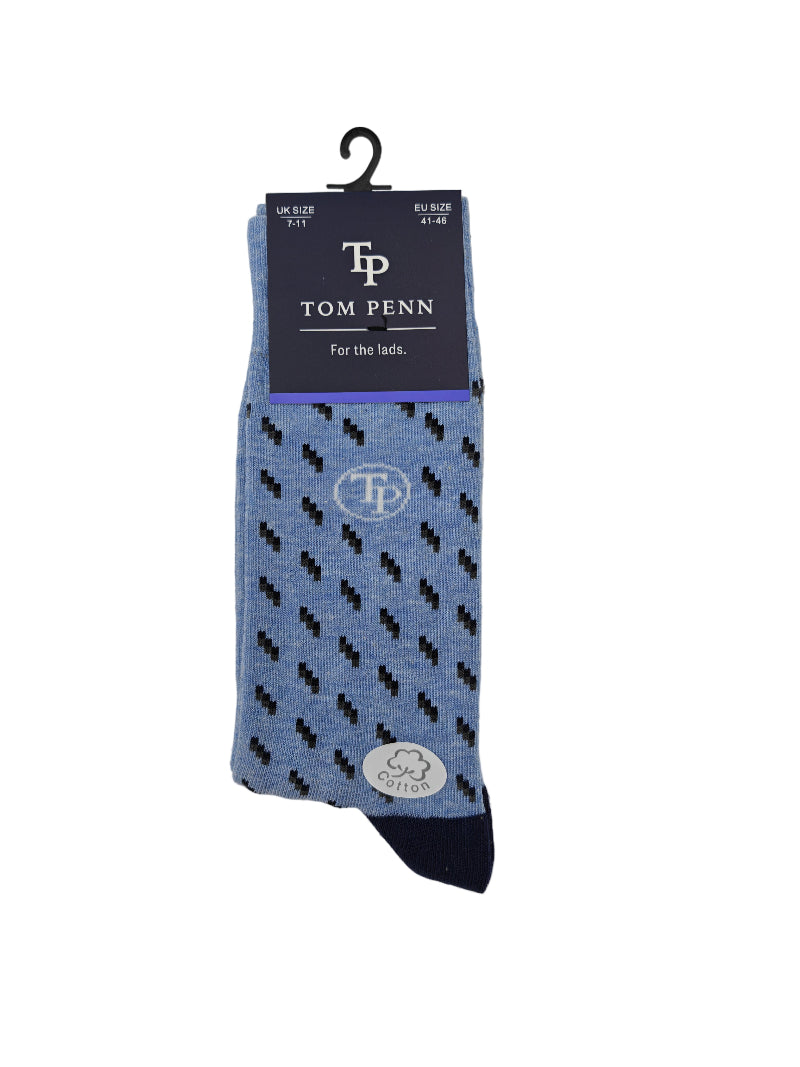 Blue patterned sock with black dots on a gray background, featuring the brand 'Tom Penn'.