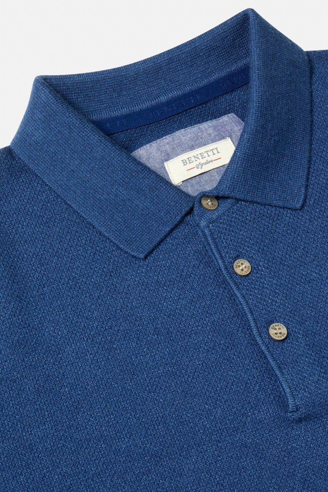 Close-up of the Benetti Trevor Indigo Polo showing the collar, button placket and woven logo label.
