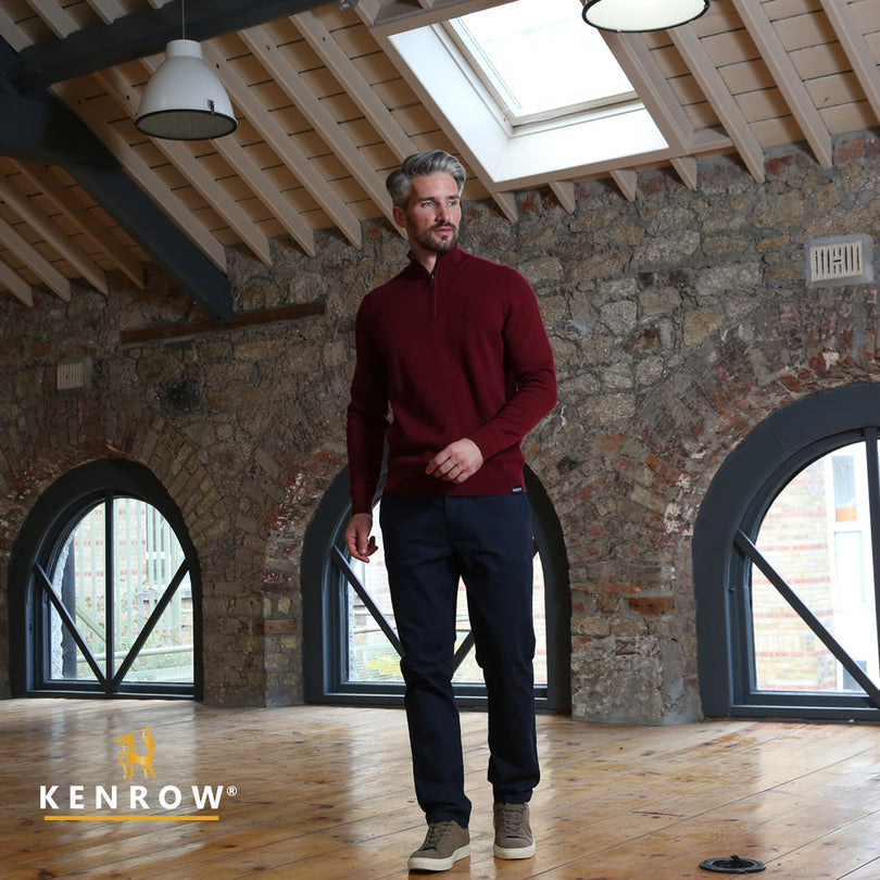 Man wearing a ruby colour half zip jumper looking left