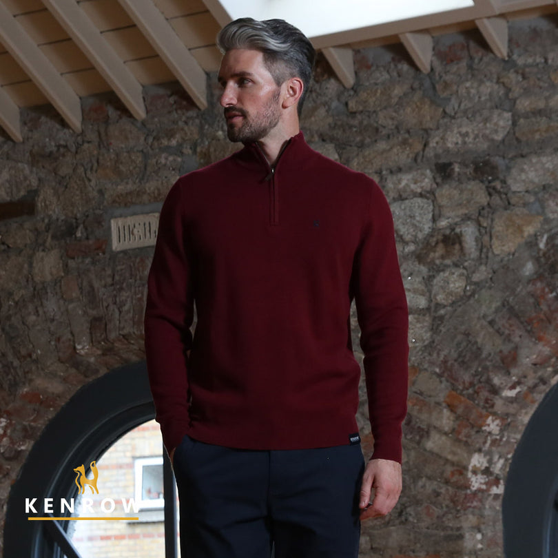 Man wearing a ruby colour half zip jumper looking right