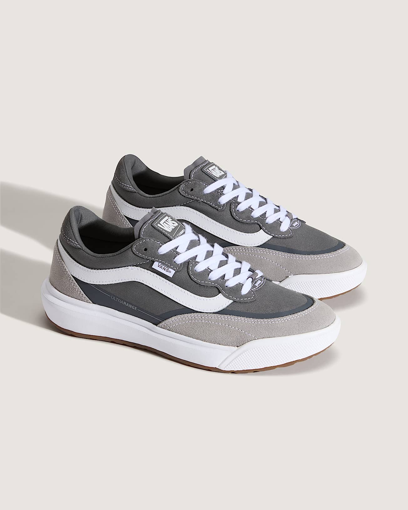 Pair of gray sneakers with white laces on a light background