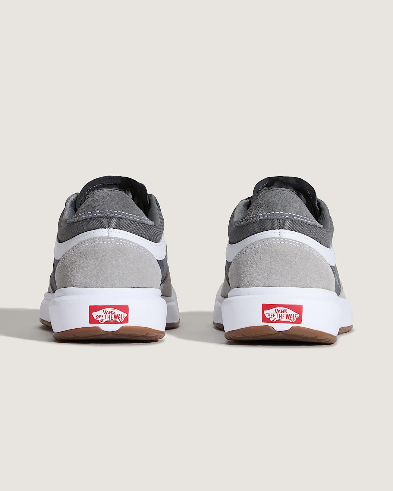 Gray sneakers with brown soles on a light beige background