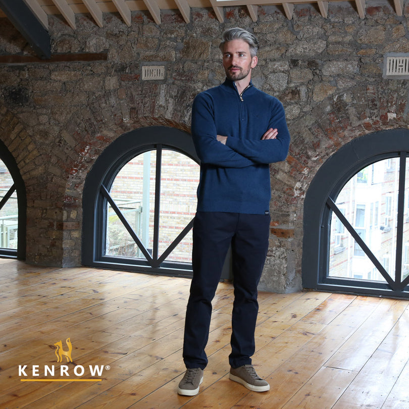 Man wearing a half-zip blue melange knit looking right