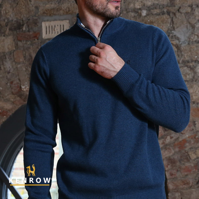 Close up of a man wearing a half-zip blue melange knit