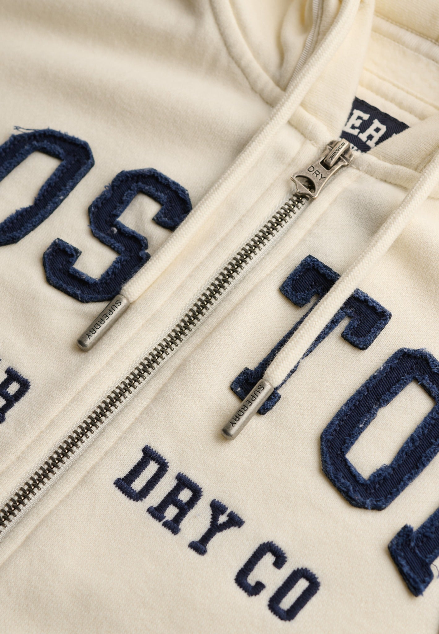 Superdry Ath Essential Relaxed Crop Ziphood in Desert Bone Off White zip and logo detail