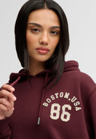 Superdry Ath Essential Applique Crop Hood in Port Red applique angled view
