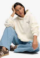 Seated view of Superdry Drop Needle Velour Hoodie in Cream