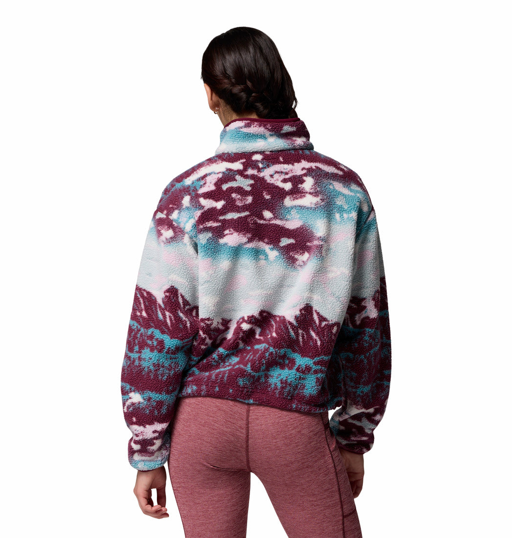 Person wearing a colorful fleece jacket with a white background