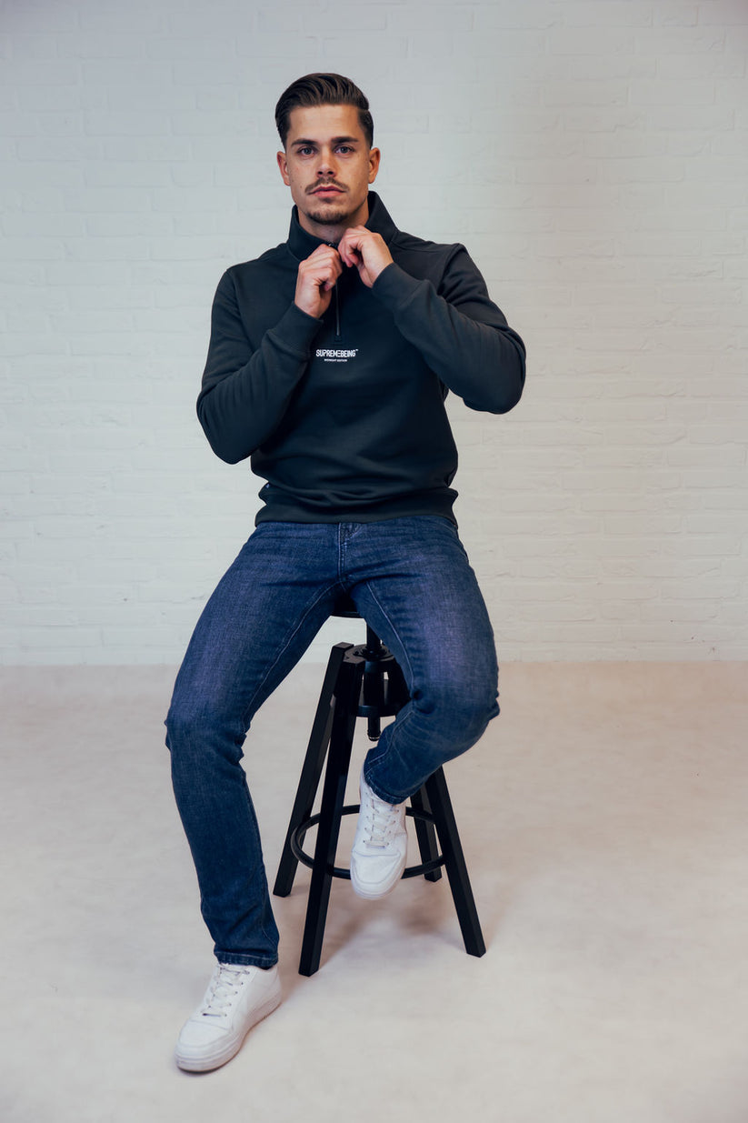 Man wearing a dark green zip up sweatshirt