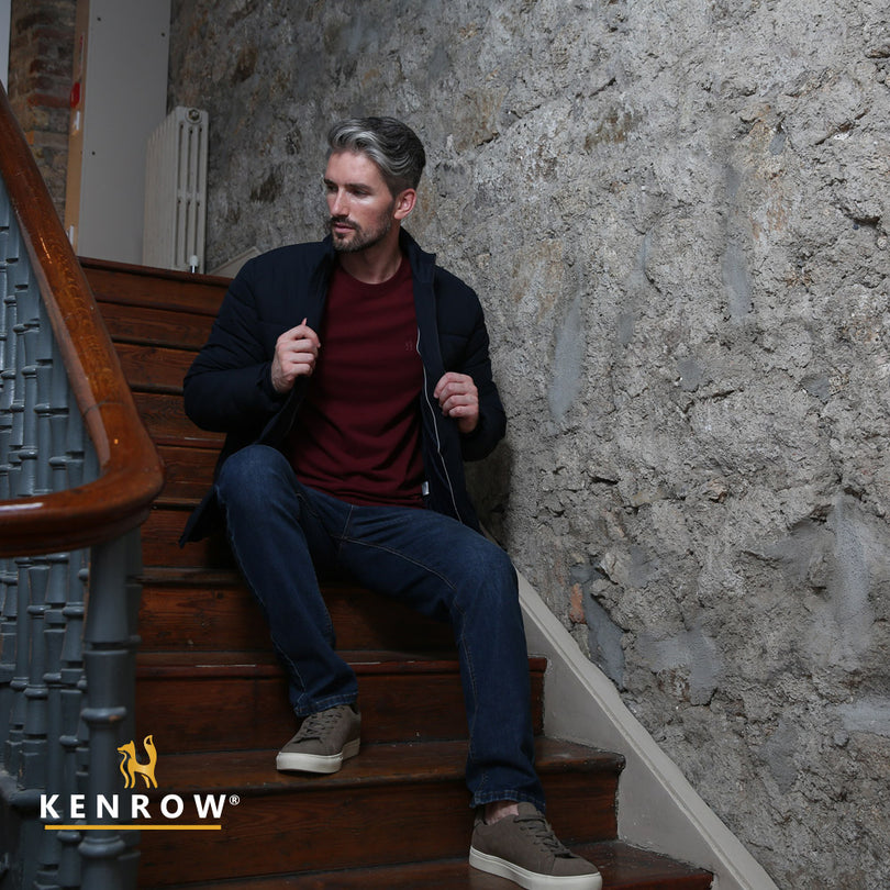 Man wearing navy puffer jacket sitting on a stairs