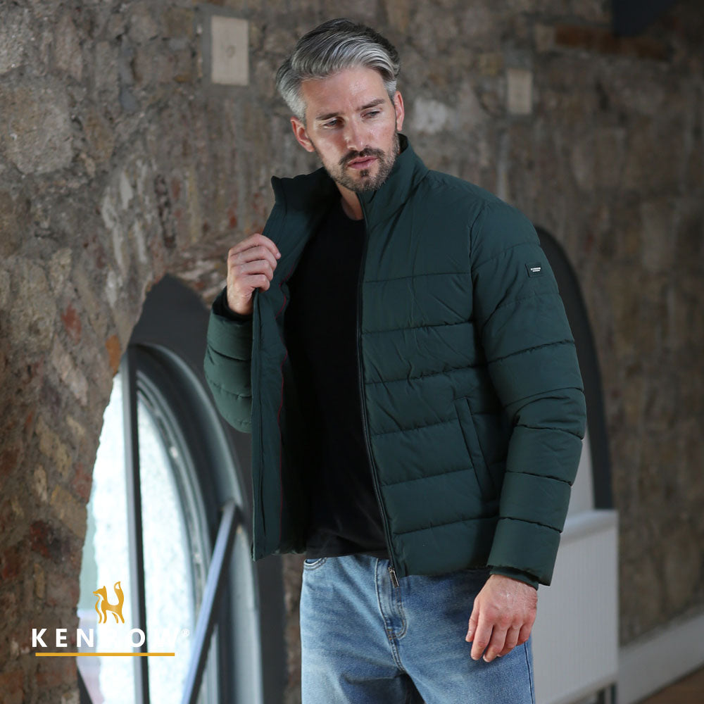 Man wearing a dark olive puffer jacket looking left