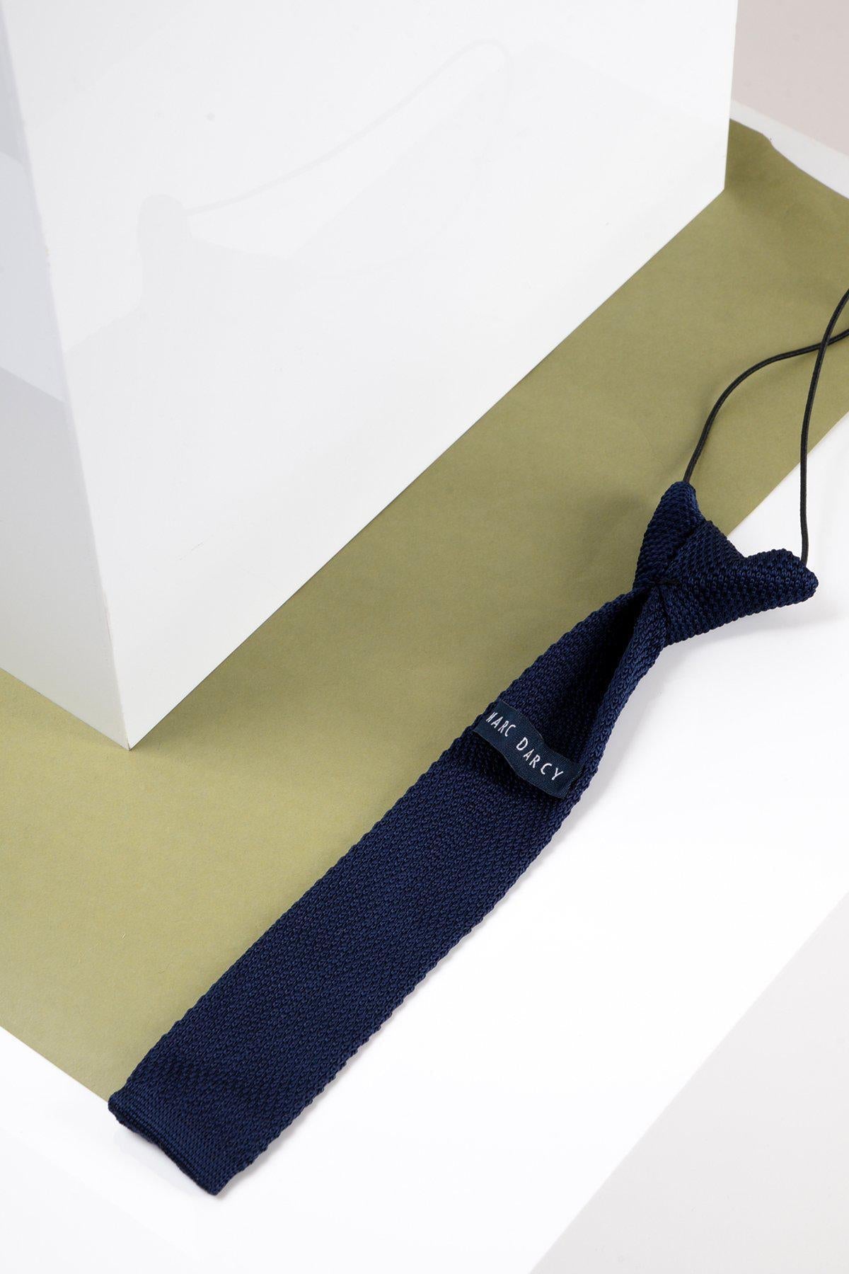 Navy blue kid boy knitted tie on a white and green background