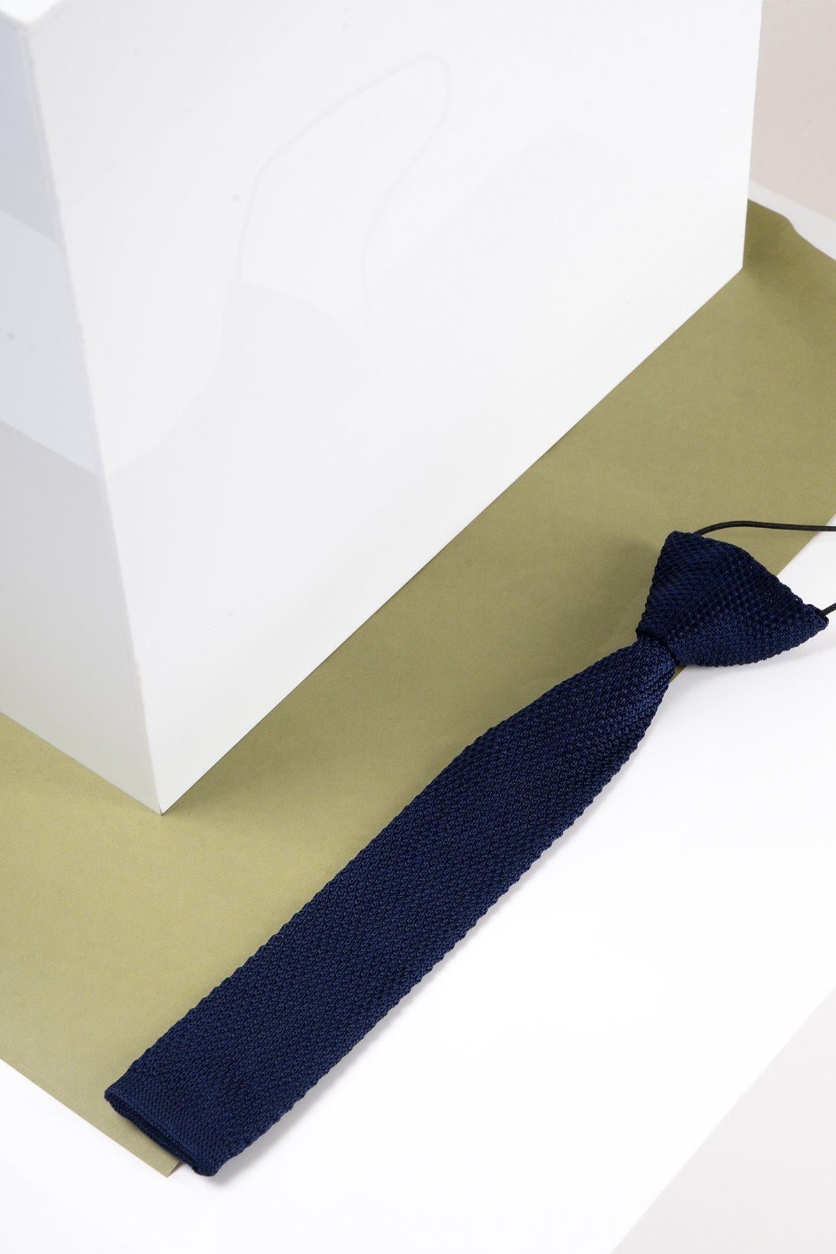 Navy blue kid boy tie on a white and beige background