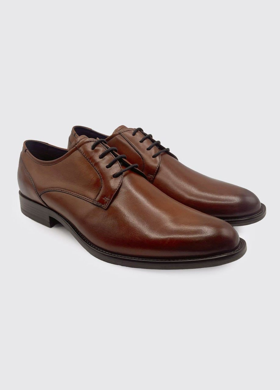 Pair of brown dress shoes on a light gray background