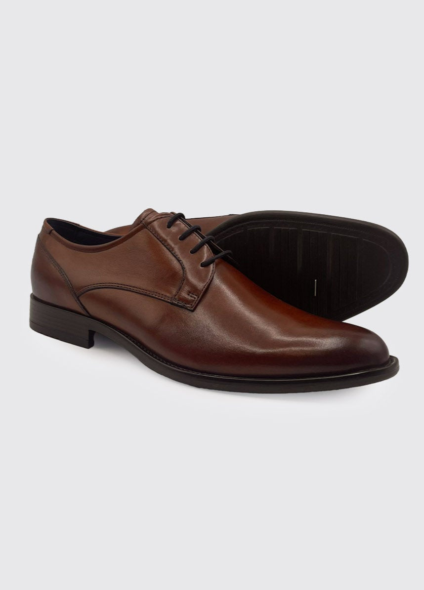 Brown leather dress shoes on a light gray background
