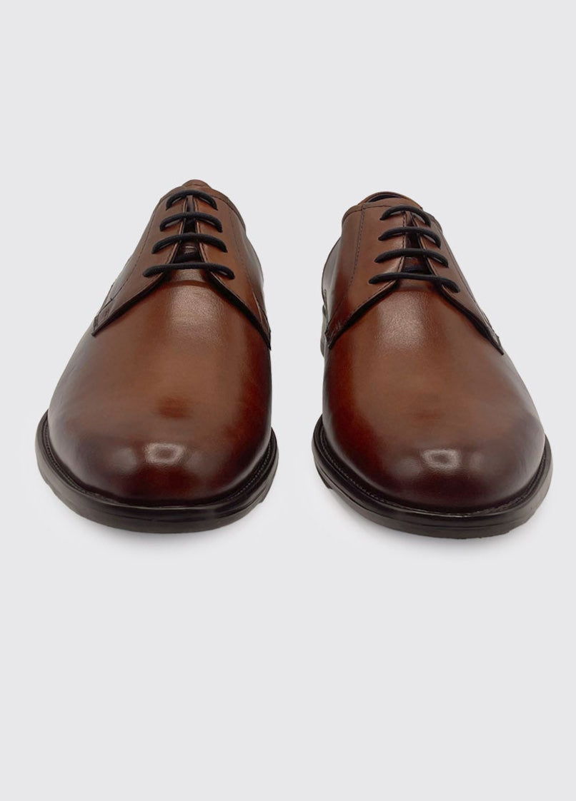 Pair of brown leather dress shoes on a white background