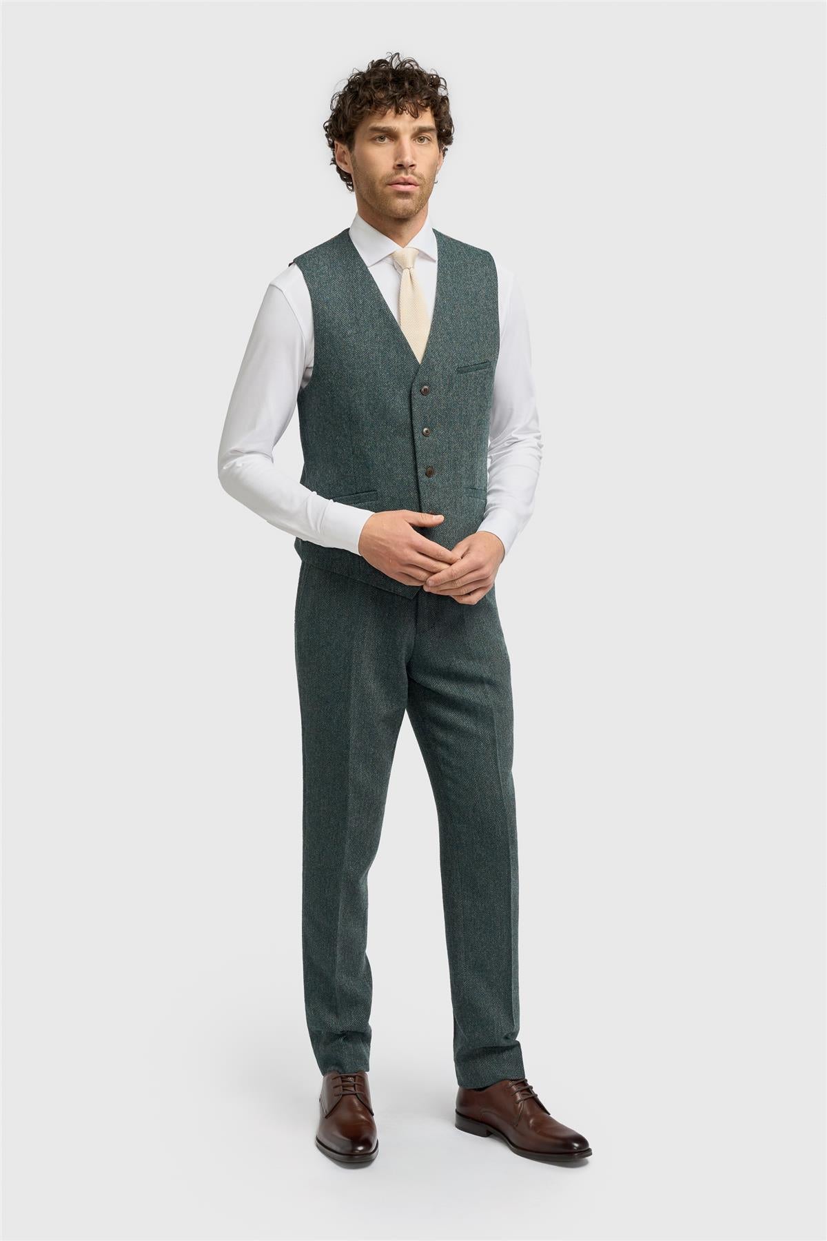 Man wearing a green suit vest and pants on a white background