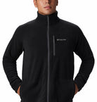 Person wearing a black fleece jacket with Columbia logo on a white background
