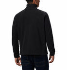 Person wearing a black long-sleeve fleece on a white background