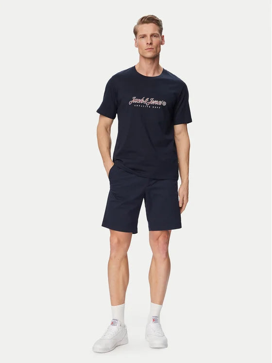 Man wearing a navy t-shirt and shorts with a brand logo on a white background