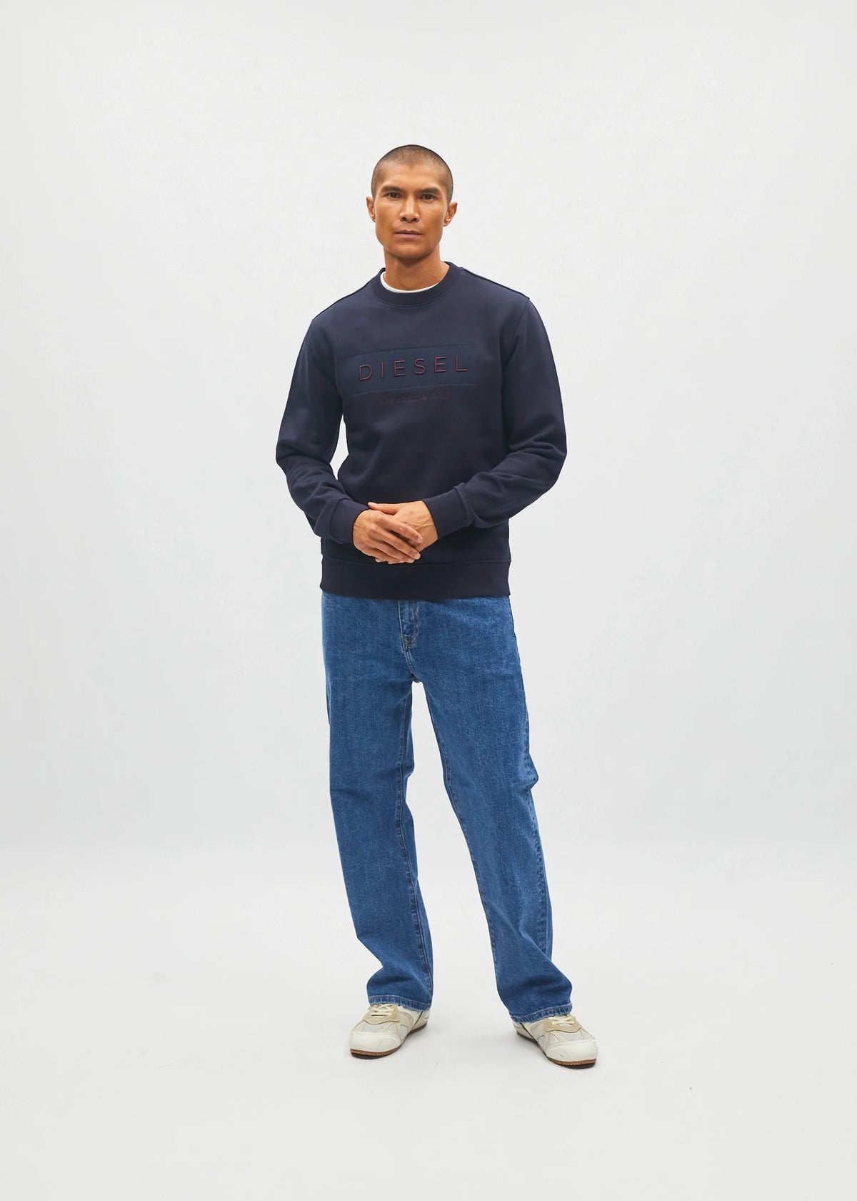 Diesel Jan Sweatshirt in Metro Navy, front model view with hands clasped showing the regular fit.