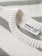 Close-up of a striped sweater with a brand label on a white background