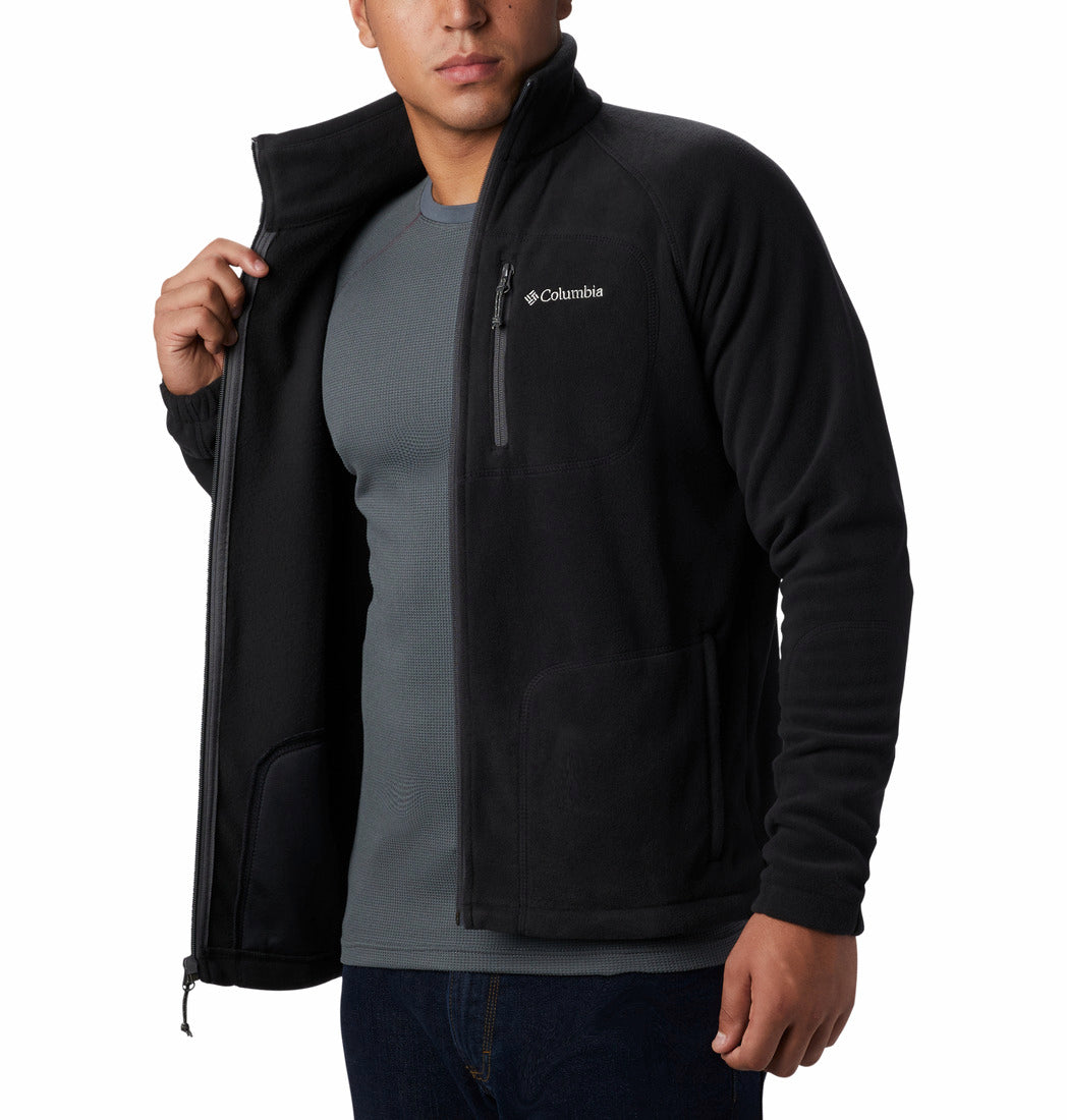 Person wearing a black Columbia jacket over a gray shirt on a white background