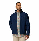 Man wearing a navy blue jacket with Columbia logo on a white background