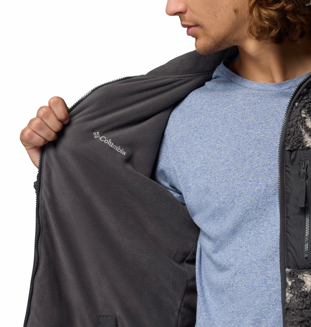 Person wearing a gray reversible jacket with Columbia logo, close-up view