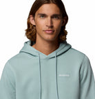 Man wearing a light blue hoodie with Columbia logo on a white background