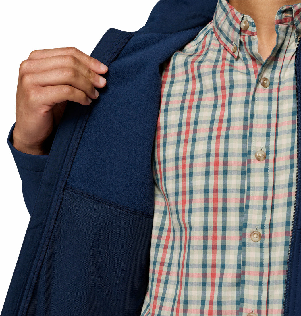 Person wearing a navy jacket and plaid shirt on a white background