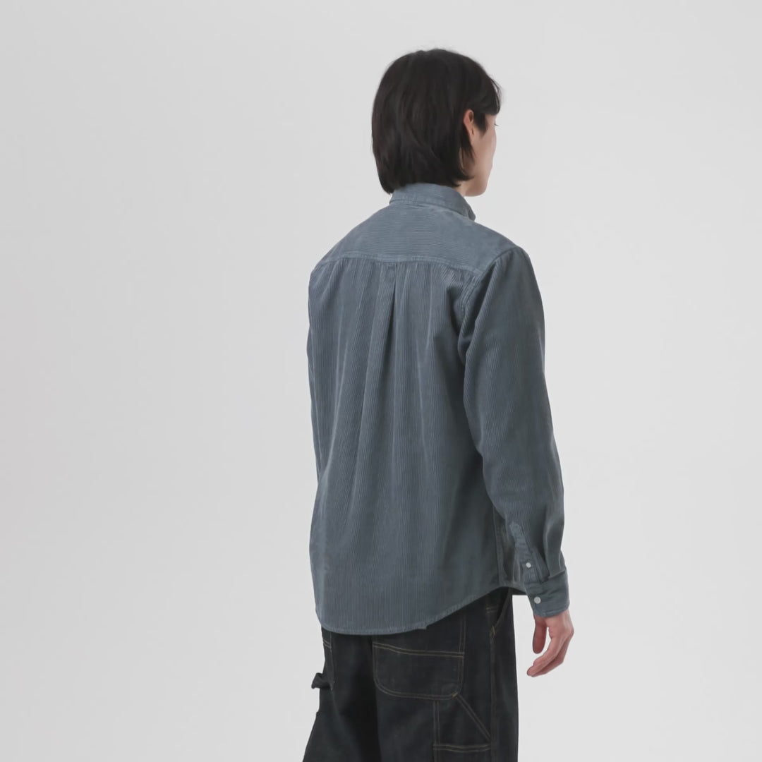 Man wearing blue button-up cord shirt on a white background