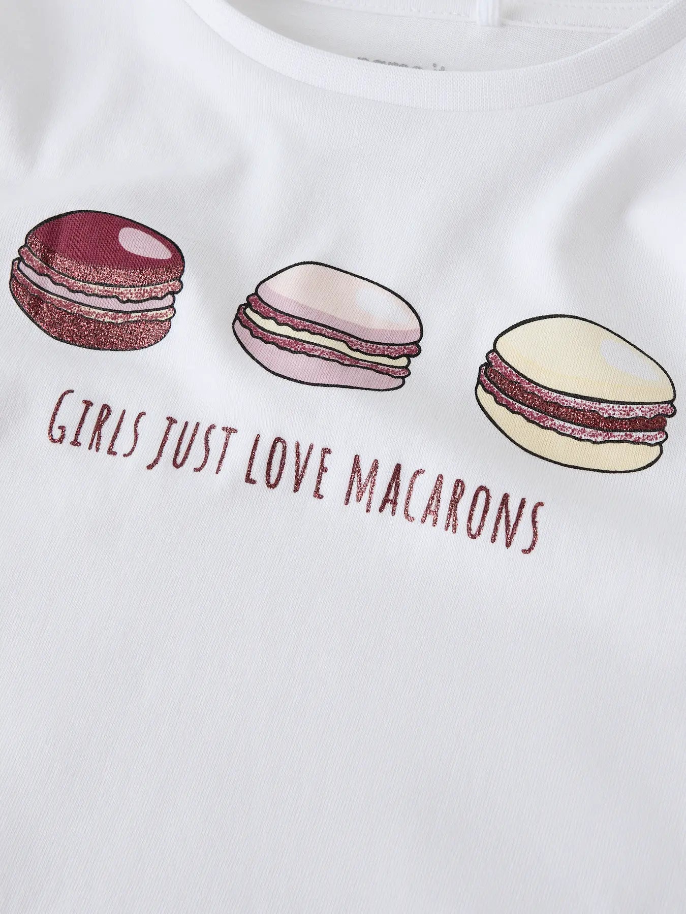 White t-shirt with macaron illustrations and text 'Girls Just Love Macarons' on a white background