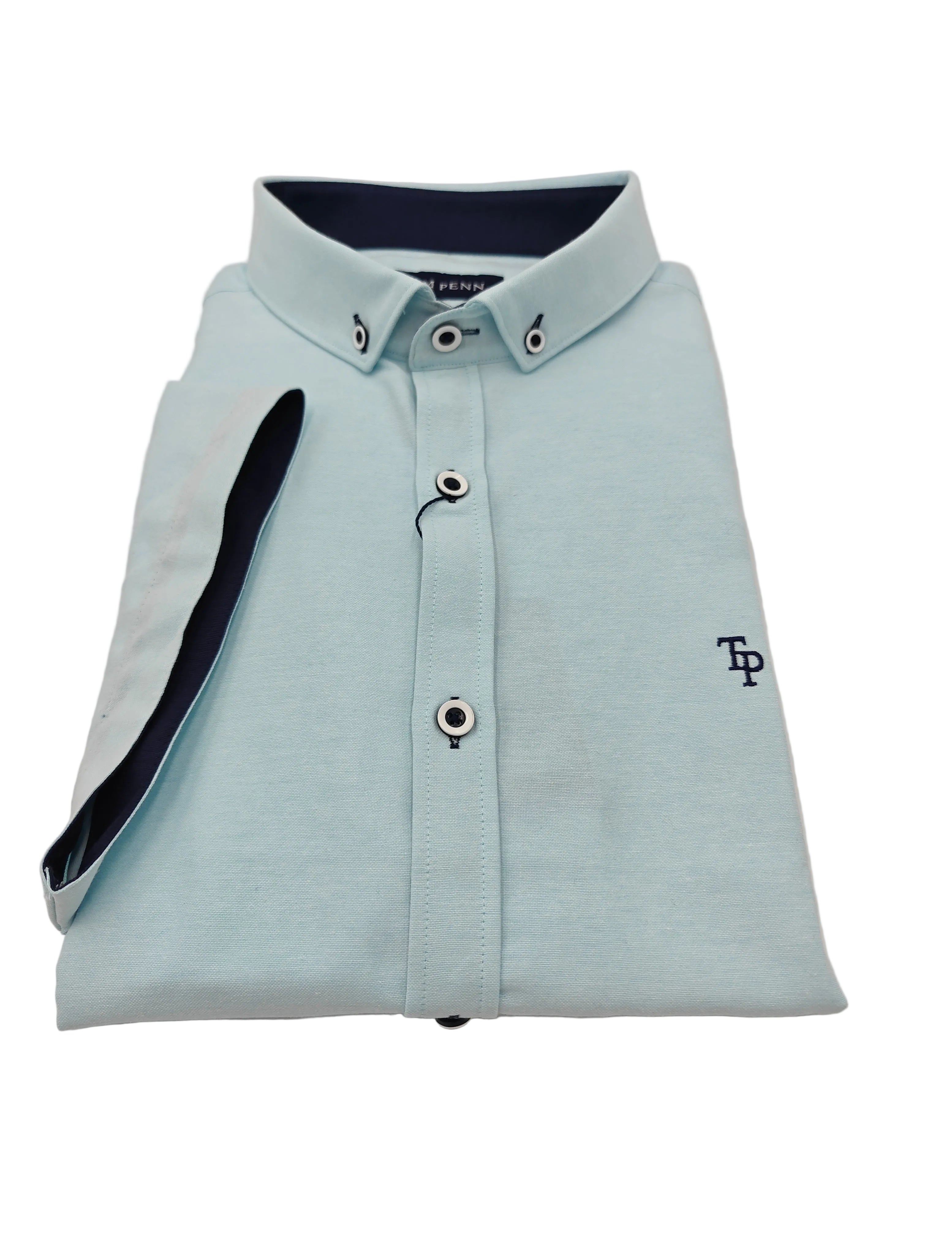 Folded ocean blue shirt with dark collar and navy logo on a white background